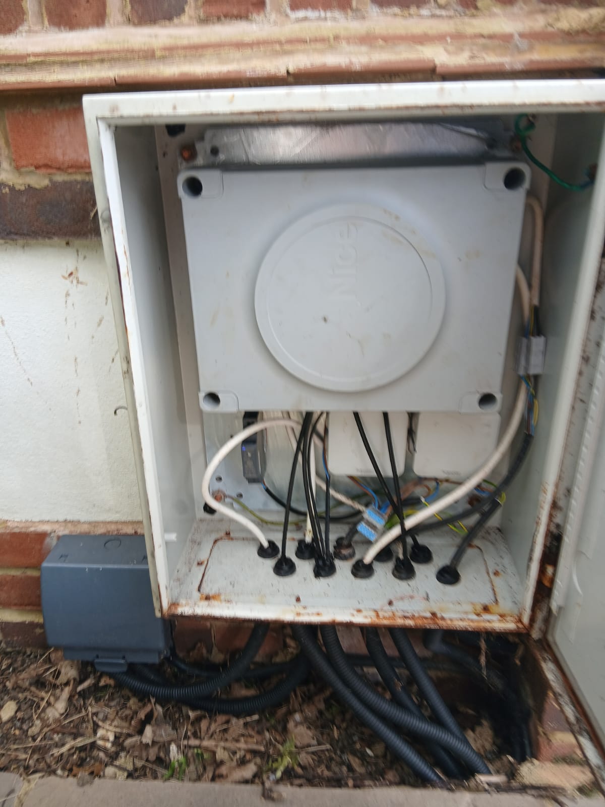 Old control cabinet with corroded steel housing and tangled wiring