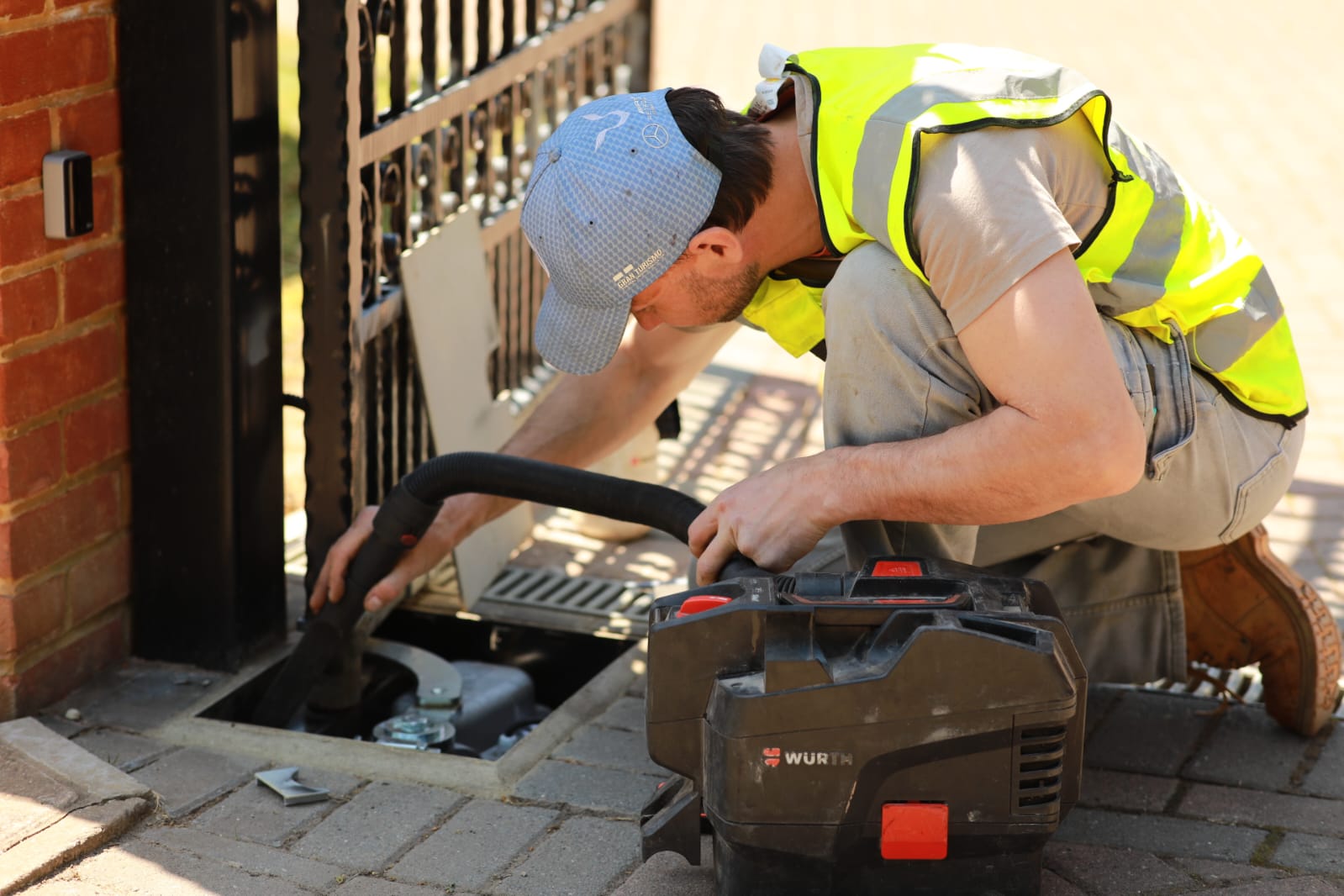 Engineer retrofitting automation to an existing gate, cleaning the motor foundation box